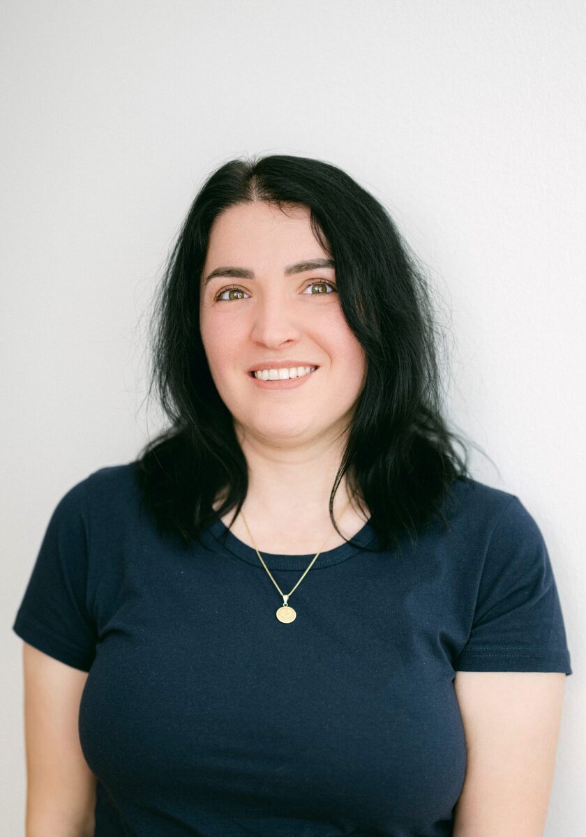 Frau Jashari trägt eine goldene Kette und schulterlanges, schwarzes Haar.